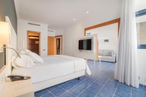 普拉亚布兰卡Hotel Mirador Papagayo by LIVVO的卧室配有白色的床和电视