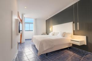 普拉亚布兰卡Hotel Mirador Papagayo by LIVVO的卧室设有一张白色大床和一扇窗户。