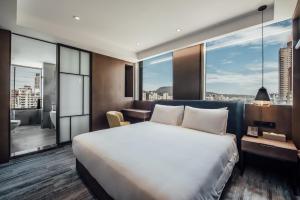 高雄钧怡大饭店的酒店客房设有一张床和一个大窗户