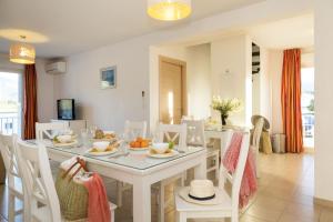奥莱塔Résidence Odalys Casa d'Orinaju的一间配备有白色桌椅的用餐室
