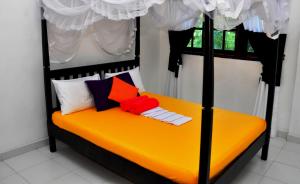 米瑞莎米瑞莎博爱考迪住宿加早餐旅馆的一间卧室配有黑色和橙色的床和枕头