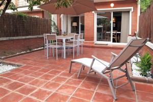 帕拉福尔斯Vivalidays Casa Pinell - Palafolls - Costa Barcelona的庭院配有桌椅和遮阳伞。