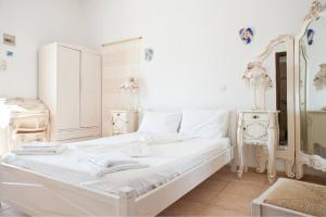 利瓦迪奥Hotel Albatross的白色的卧室配有白色的床和镜子