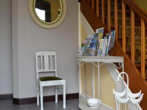 韦姆Spacious Cottage in Thirimont near Forest的椅子、桌子、书籍和镜子