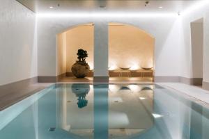 赫尔辛基赫尔辛基圣乔治酒店的一座在房间中间种植植物的游泳池