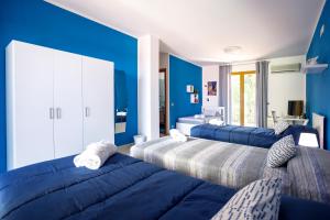 帕泰尔诺Rocca degli Etnei的一间拥有蓝色墙壁和两张床的卧室