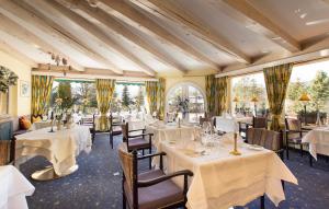 蒂罗尔-泽费尔德伯格瑞斯特泽费尔德酒店的餐厅设有白色的桌椅和窗户。