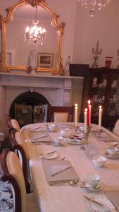 香农河畔卡里克Hartley House B&B的用餐室配有带蜡烛的桌子和壁炉