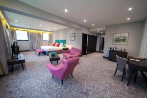 韦姆豪科斯通公园旅馆的酒店客房带粉红色的椅子和床