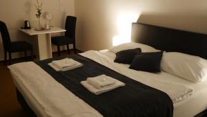 特热邦白小马酒店的一间卧室配有一张床,上面有两条毛巾