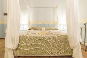 明乔河畔的瓦雷奇奥Agriturismo e Agricamping Le Nosare的卧室配有带白色窗帘的天蓬床