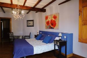 La BustaTrisileja en Posada La Busta的一间卧室配有蓝色的床和吊灯。