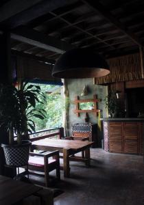 武吉拉旺Waterstone Guesthouse的一间带木桌和椅子的用餐室