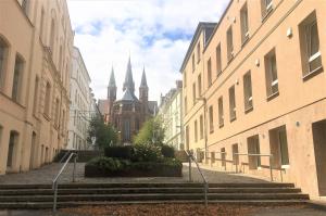 什未林Schwerin Apartment am Pfaffenteich的一条有楼梯的小巷和一座有教堂的建筑
