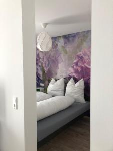 巴德塞尔佐根Walnusshof Bad Salzungen的一张带白色枕头和花卉墙的床