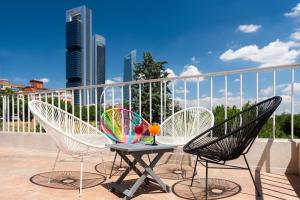 马德里Hotel Madrid Chamartín, Affiliated by Meliá的阳台配有两把椅子和一张桌子,并提供饮品