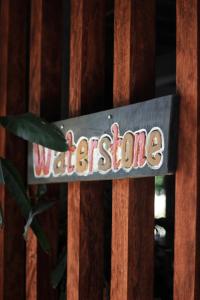 武吉拉旺Waterstone Guesthouse的木栅栏上的水屋标志