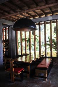 武吉拉旺Waterstone Guesthouse的用餐室配有木桌和吊灯