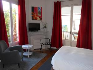 尼斯辛格涅斯别墅酒店的一间卧室配有红色窗帘、一张床和一个壁炉