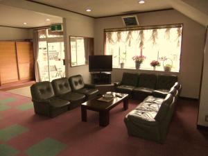 富士河口湖西宫荘酒店的带沙发、桌子和电视的客厅
