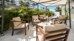 英格兰海滩Villa RG Boutique Hotel - Adults Only的庭院配有桌椅和遮阳伞。