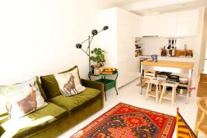 里斯本Swimming pool Apartment Central Lisbon的一间带绿色沙发的客厅和一间厨房