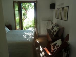 喇沙La Pâquerette的卧室配有床、椅子和窗户。