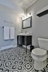 惠灵顿乡村套房公寓的浴室配有白色卫生间和盥洗盆。