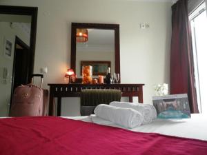 加拉塔斯阿卡迪亚套房酒店及水疗中心的一间卧室配有一张床和一张带镜子的桌子