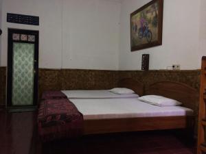 庞岸达兰迷你蒂加民宿的一间卧室配有床、窗户和床罩。