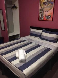 亚娄密特罗伊恩酒店的一张带蓝色和白色条纹床单和枕头的床