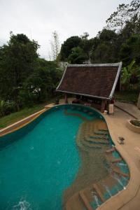 琅勃拉邦Shangri-Lao Resort的一座游泳池,其建筑背景为: