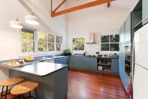 科夫斯港杰特度假屋的厨房配有蓝色橱柜、木地板和窗户。