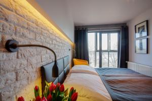 托伦萨那洛扎酒店的一间卧室设有砖墙和一张鲜花床