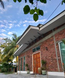 Huma丹绒鲁泳池TRV度假屋的砖砌的建筑,设有棕色的木门