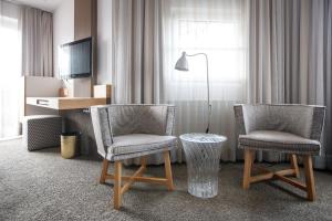 湖滨福煦Hotel Jakob的酒店的客房内设有2把椅子和1张桌子
