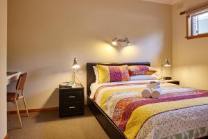 布赖特金丰假日酒店的一间卧室配有一张带书桌的床和一张四柱床。