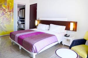 万隆万隆森萨酒店的酒店客房带一张大床和一把椅子