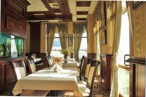 奥布佐尔Hotel Dukov的用餐室设有2张桌子和椅子以及窗户。