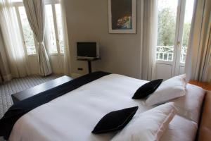 阿尔巴塞特阿尔巴塞特格兰酒店的卧室配有带枕头的白色床和电视。