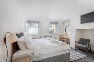 普里茅斯Rooms by Bistrot Pierre的卧室配有一张白色大床和一把椅子