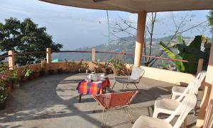 大吉岭Misty Views- Susama Villa的庭院配有桌椅和遮阳伞。