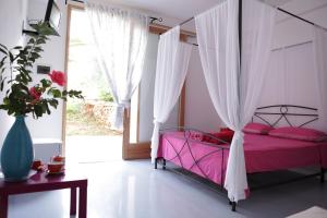 帕图B&B Yatabui的一间卧室配有一张粉红色的床和天蓬