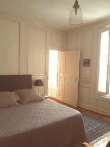 桑特La Maison des Thermes, Chambre d'hôte的一间卧室设有床、两个窗户和一扇门
