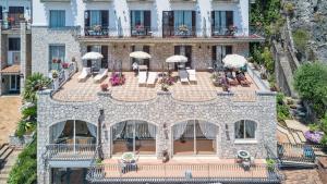 陶尔米纳圣卡塔林纳宫阿里斯顿酒店的享有带椅子和遮阳伞的建筑的空中景致