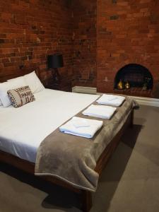 旺加拉塔Sublime Spa Apartments的带壁炉的客房内的一张带毛巾的床