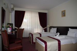 图尔恰尤洛普里斯酒店的酒店客房配有两张床和一张书桌