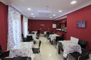 锡古恩萨哈西斯贵恩扎酒店的一间设有桌椅和红色墙壁的餐厅