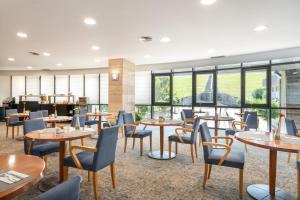 圣地亚哥－德孔波斯特拉中心区EXE酒店的餐厅设有桌椅和窗户。
