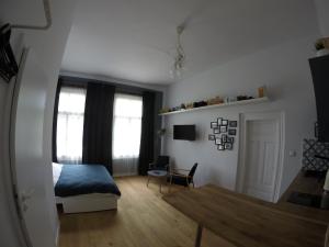 纳文丘夫Atelier Foto Lipowa - Apartamenty的一间卧室,卧室内配有一张床和一把椅子